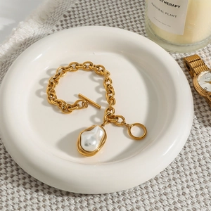 Baroque pearl bracelet with gold 18k stainless steel chain and OT toggle clasp on a tray