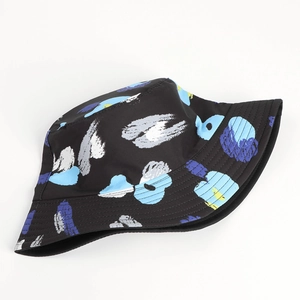 Detailed flat lay of reversible tie-dye bucket hat with blue and yellow abstract leaf print