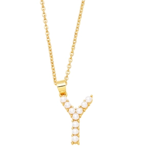 Detail of gold letter Y pendant necklace inlaid with white faux pearls on white background