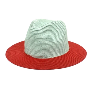 Detail of two-tone woven straw hat with green crown and contrasting red wide brim