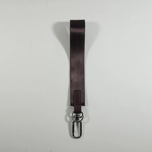 Dettaglio di un portachiavi da polso in nylon intrecciato marrone con gancio argento