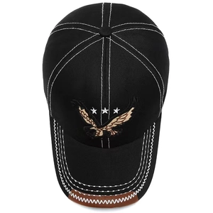 Close-up of black baseball cap featuring eagle embroidery and white contrast stitching detail
