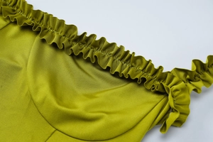 Detailansicht des limettengrünen Rüschen-Ausschnitts und der Textur des Strickkleids