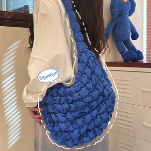 Blue ruched cloud shoulder bag with bubble pleat texture shown on a female model
