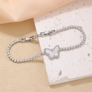 Detail of silver tennis bracelet with butterfly charm, zirconia inlay and shell finish