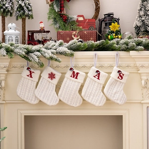 Set of five white knitted Christmas stockings with red embroidered festive letters and snowflake