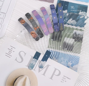 Detailed flat lay of magnetic bookmarks with scenic cloud and landscape art designs