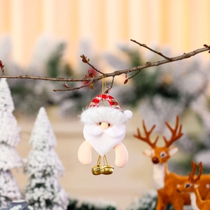 Detail of plush Santa Claus ornament with red plaid hat and golden bells on a tree