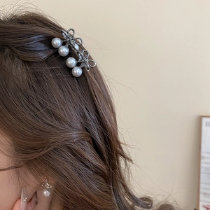 Close-up of elegant mini pearl bow hair clips worn on side hair for a stylish look