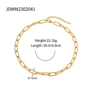 Detail of gold paperclip chain necklace showing textured links and lobster clasp closure