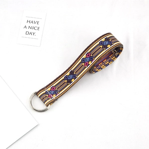 Close-up of ethnic woven canvas belt with geometric patterns and metal D-ring buckle