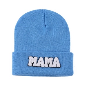 Detail of blue knitted beanie featuring white MAMA towel embroidery patch