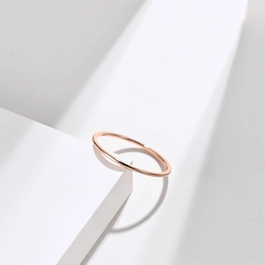 Polished rose gold minimalist stackable stainless steel 1mm band ring on white background