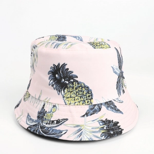 Detailed pattern of tropical pineapple and blue leaves on pink cotton bucket hat fabric