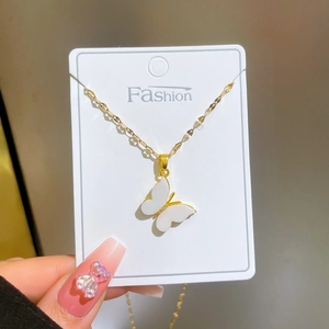 Titanium steel gold necklace with white butterfly shell pendant and pavé crystals on a card