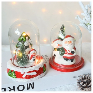 Close-up of lighted Christmas glass globes with Santa and snowman on red bases