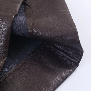 Primer plano de la textura de piel sintética marrón oscuro con forro de tela gris