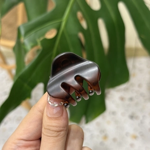 Close-up of a tortoiseshell acetate hair claw clip with a glossy finish and smooth teeth