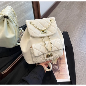 Detail view of quilted beige mini backpack with gold chain straps and twist locks