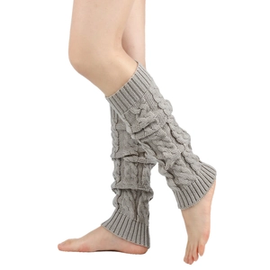 Detail of grey cable knit leg warmers showing thick twist pattern and ribbed cuffs