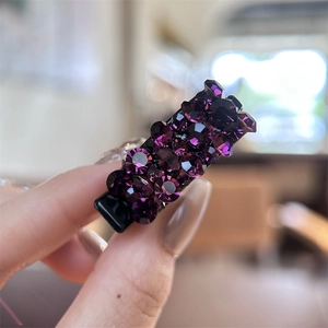 Vue macro d'une petite pince à cheveux en métal avec des strass violets ronds brillants