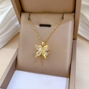 Macro view of a gold-plated butterfly pendant with zircon inlay on a velvet jewelry box
