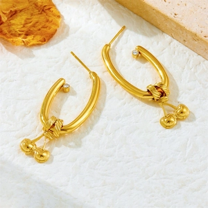 Elegant 18K gold plated cherry drop earrings with crystal accents on a textured surface