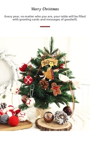 Detailed view of mini Christmas tree with knitted balls, gingerbread man, and LED lights