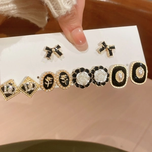 Close-up of vintage jewelry set featuring pearl camellia flowers and bow earrings