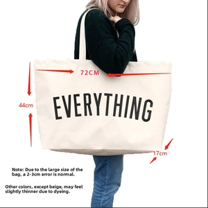 Detail showing oversized white canvas tote bag with Everything print and wide shoulder strap