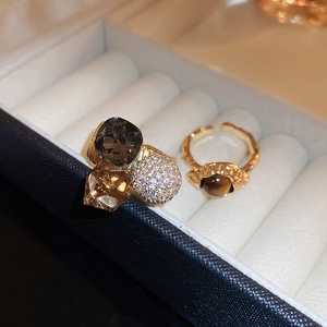 Close-up of gold-plated rings featuring square zircon and vintage tiger eye stones