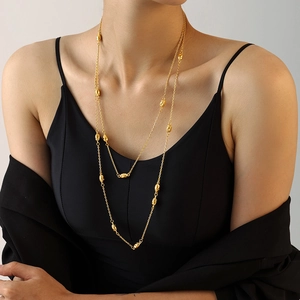 Double-layered gold titanium sweater necklace with irregular beads on female model