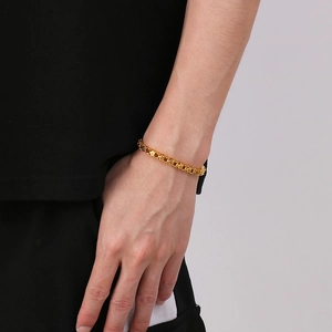 Dettaglio di un bracciale da uomo in acciaio inossidabile oro opaco con maglie quadre