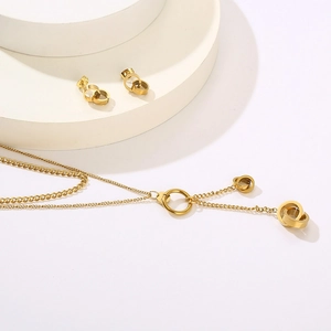 Detailed view of 18K gold plated double layer necklace and interlocking ring earrings