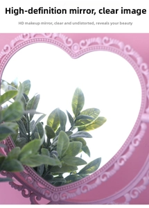 Close-up of a pink heart-shaped vintage vanity mirror with detailed floral relief patterns