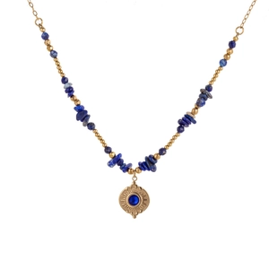 Detailed macro of gold sunburst pendant with blue gemstone and matching stone beads