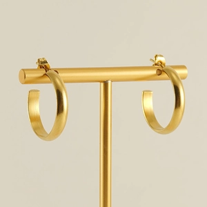 Classic 18k gold-plated stainless steel C-shaped hoop earrings on a metal jewelry stand