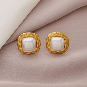 Detailed macro view of vintage square pearl earrings with textured gold metal frame