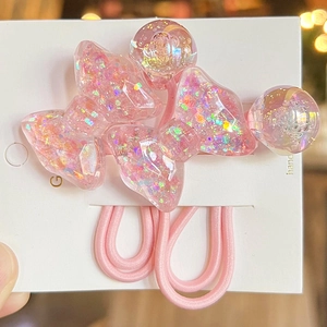 Detail of pink resin hair ties with glitter bows and beads on display card