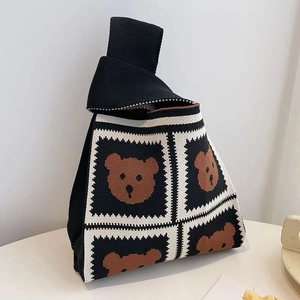 Detail of a black and white checkered knit tote bag with cute brown bear patterns