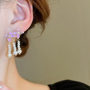 Detailed close-up of pink enamel flower earrings with sparkling zircon and pearl tassels