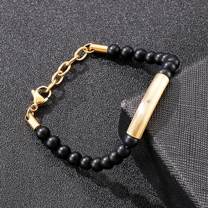 Detail of matte black beads and gold brushed metal tube on adjustable men's bracelet