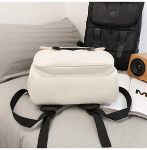 Rear view of white minimalist backpack featuring wide black adjustable shoulder straps