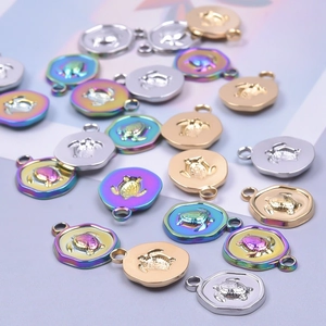 Dettaglio di pendenti a tartaruga esagonale in oro, argento e finitura arcobaleno