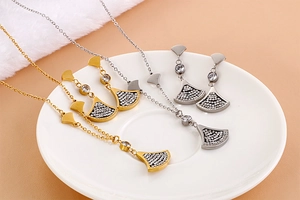 Detail of gold and silver fan-shaped jewelry set with crystal inlay and Forever Love engraving