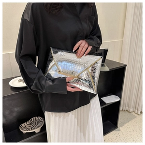 Detailed macro view of silver envelope clutch with luxury crocodile leather texture and metal bar