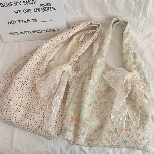 Detailed top view of floral canvas tote bags with delicate lace bows and floral patterns