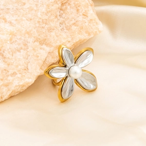 Close-up of 18K gold plated flower ring with white pearl on elegant satin fabric
