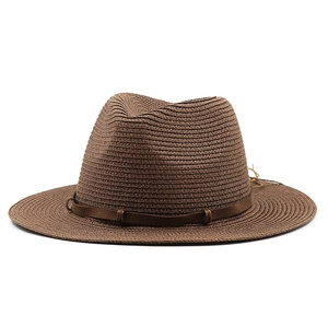 Close-up of woven straw fedora hat featuring a brown leather band and metal buckle detail