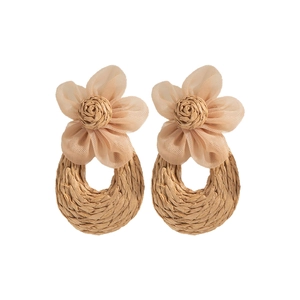 Detailed view of handmade raffia woven earrings with delicate mesh flower accents